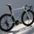 Das Konzept-Rennrad Canyon Predict in hellem Silber-Grau mit einem aerodynamisch optimierten Carbonrahmen, einer markanten integrierten Lichtleiste an der Sattelstütze und hohen Carbon-Laufrädern im Studio.