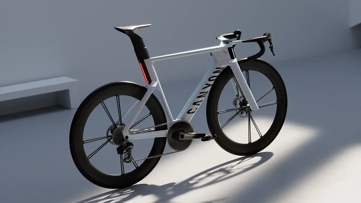 Das Konzept-Rennrad Canyon Predict in hellem Silber-Grau mit einem aerodynamisch optimierten Carbonrahmen, einer markanten integrierten Lichtleiste an der Sattelstütze und hohen Carbon-Laufrädern im Studio.
