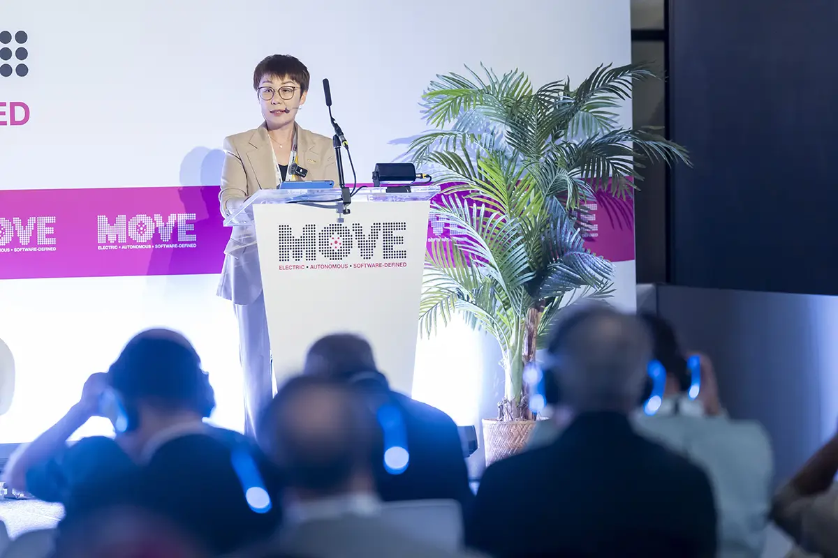 ECRI-Präsidentin Xiaojuan Wang spricht auf einem Rednerpult der MOVE-Konferenz über die Zukunft der Software Defined Vehicles.