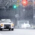 Ein weisser Fahrzeug-Prototyp absolviert Schlechtwetter-Fahrtests in der wetterkontrollierten Testhalle des Geely ECRI Zentrums mit künstlichem Schneefall.