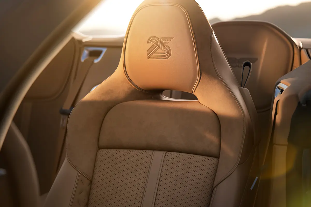 Detailansicht der braunen Leder-Kopfstütze des Aston Martin Vanquish 25 mit eingestickter Jubiläumszahl 25.