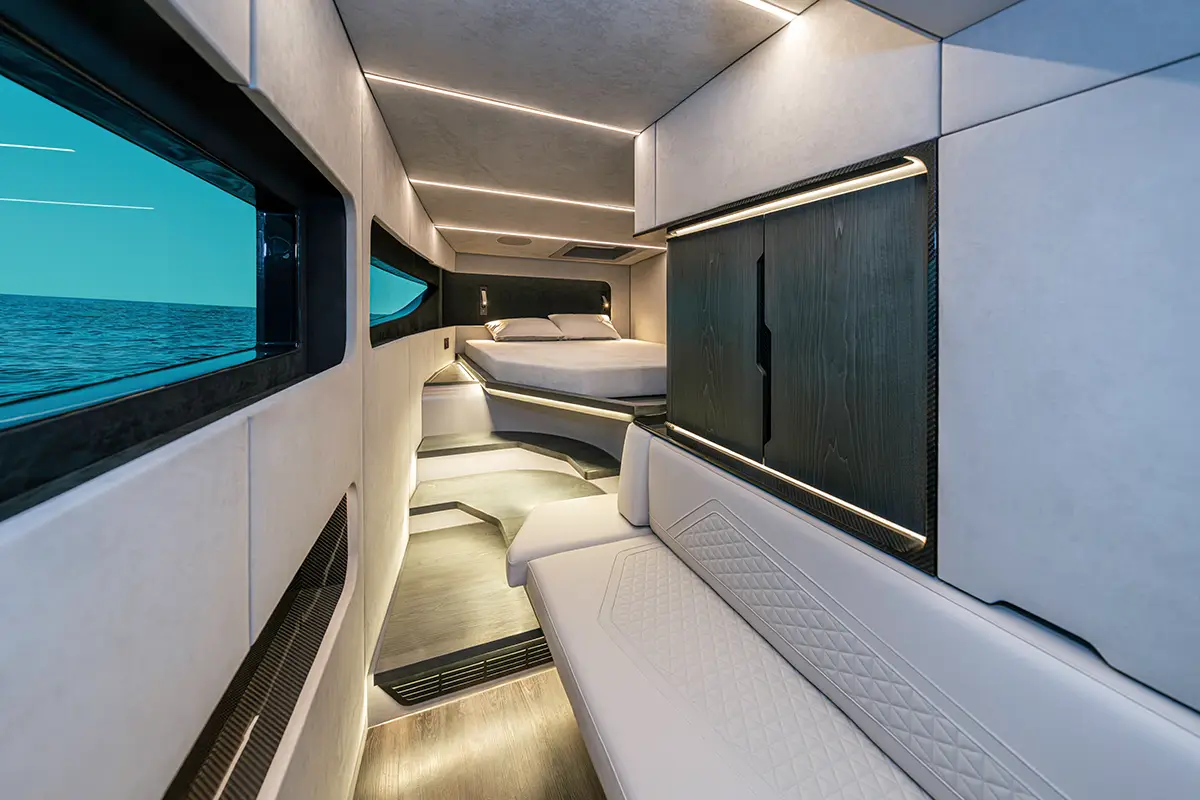Luxuriöser Korridor und Loungebereich im Rumpf der BRABUS ULTIMA 55 mit weissem Steppleder-Sofa und Sicht-Carbon-Elementen. Foto: Brabus