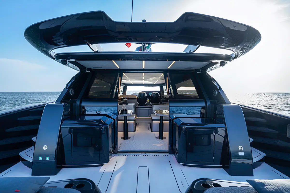 Blick vom Achterdeck der BRABUS ULTIMA 55 durch die geöffneten Schiebetüren in den beleuchteten Salon und das Cockpit. Foto: Brabus