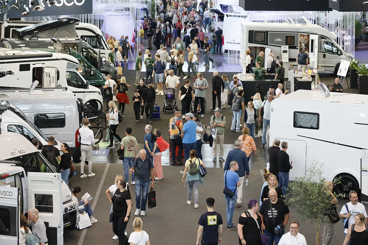 Gut besuchte und belebte Messehalle auf dem Caravan-Salon Düsseldorf mit dichtem Publikumsverkehr zwischen ausgestellten Kastenwagen und Reisemobilen.