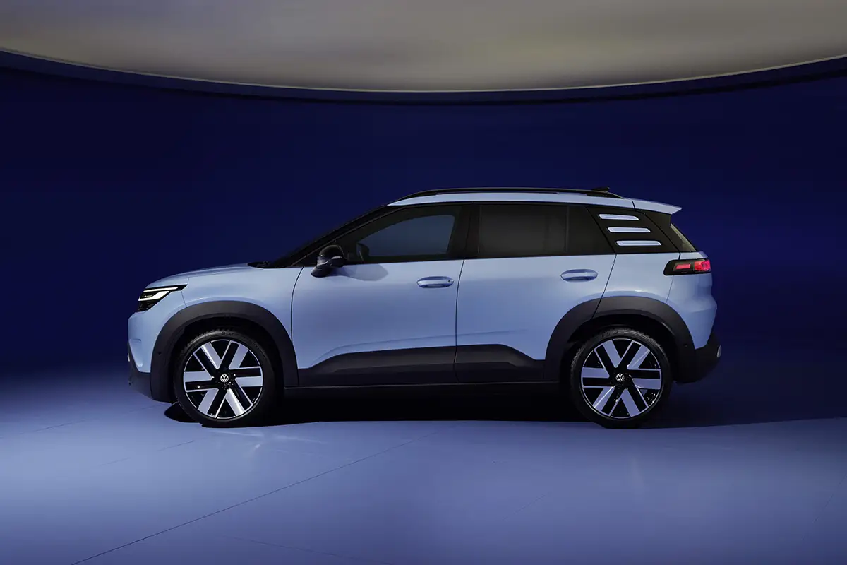 Die exakte Seitenansicht des VW ID.Cross in Hellblau, welche die kompakten Proportionen sowie die drei markanten horizontalen Zierstreifen an der C-Säule zeigt