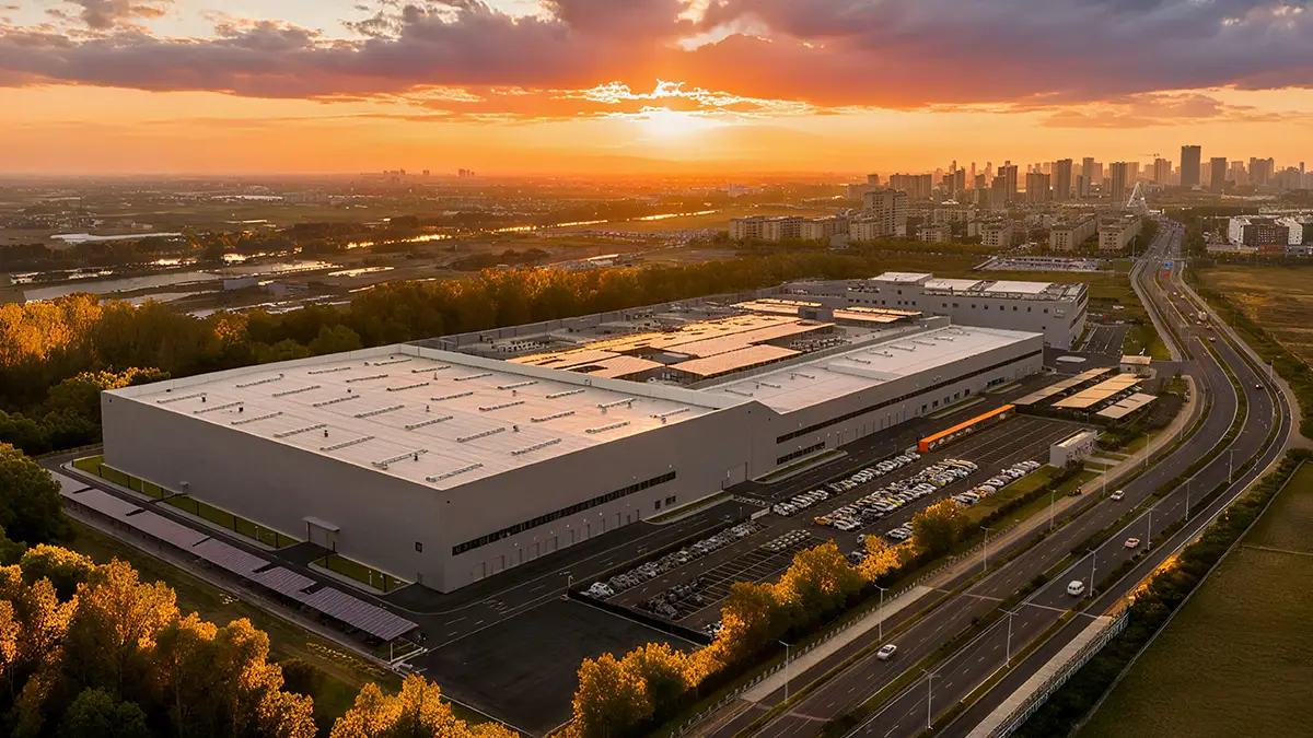 Vogelperspektive auf die riesige, 82'000 Quadratmeter grosse Testhalle von Geely bei Abenddämmerung.
