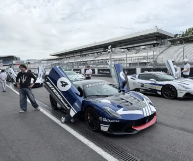Zwei exklusive Maserati Rennsportwagen, darunter ein dunkelblauer GT2 Stradale mit nach oben geöffneten Flügeltüren, stehen in der Hockenheimring-Boxengasse beim ersten Master Maserati Auslandstraining.