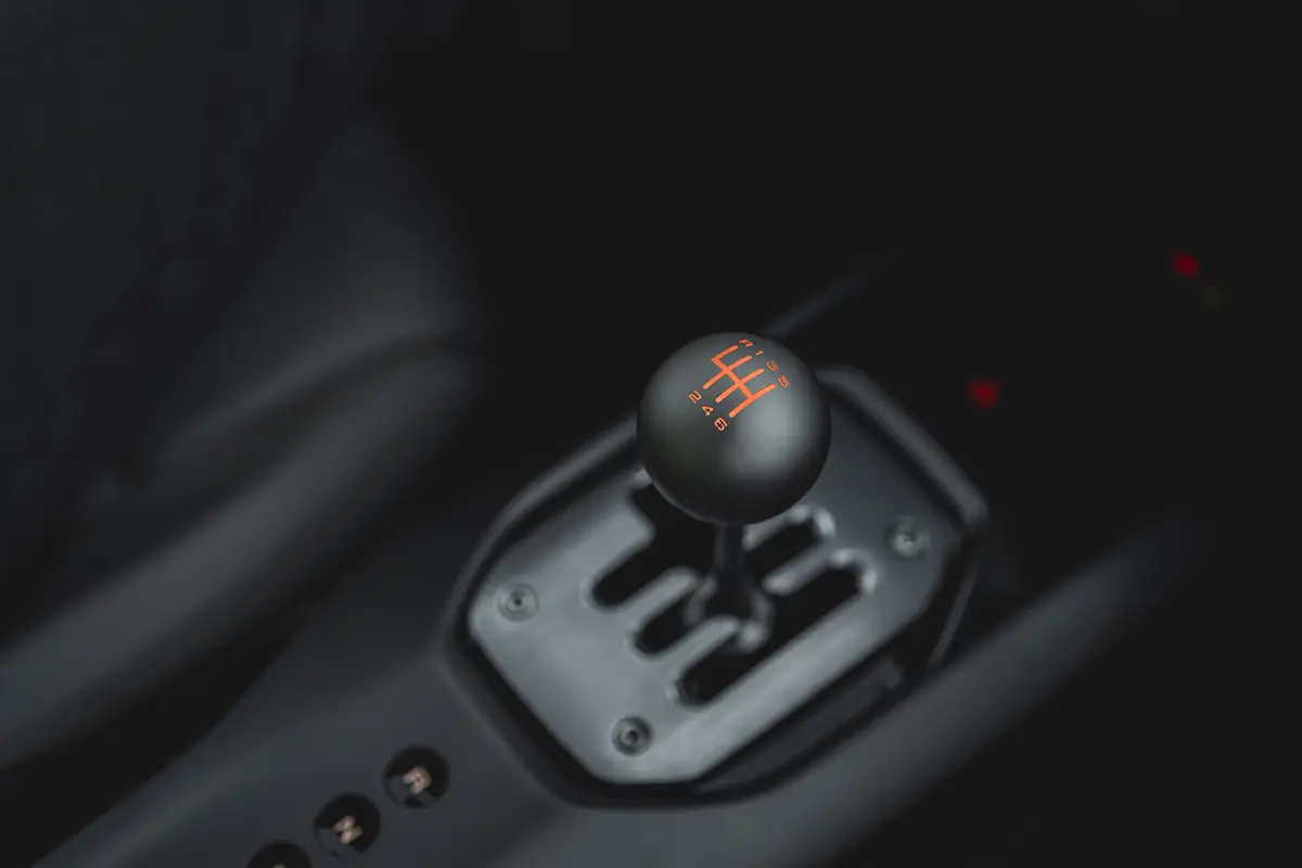 Die exklusive offene Schaltkulisse aus Metall im Cockpit des Ferrari 12Cilindri Manuale mit dem klassischen runden Schalthebel und beleuchtetem Schaltschema.