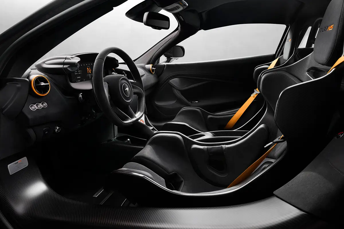 Blick in das puristische Cockpit des McLaren 788HS mit Alcantara-Sportlenkrad, digitalem Display, orangefarbenen Akzenten an den Lüftungsdüsen und einer schlanken Carbon-Mittelkonsole. Foto: McLaren