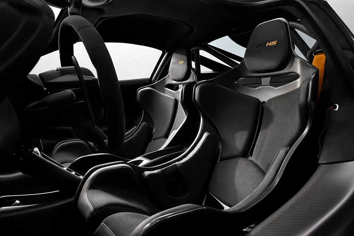 Nahaufnahme aus dem Innenraum des McLaren 788HS mit Fokus auf die eng umschliessenden Renn-Schalensitze aus Sichtcarbon mit eingesticktem, orangefarbenem '788HS'-Logo auf den Kopfstützen. Foto: McLaren