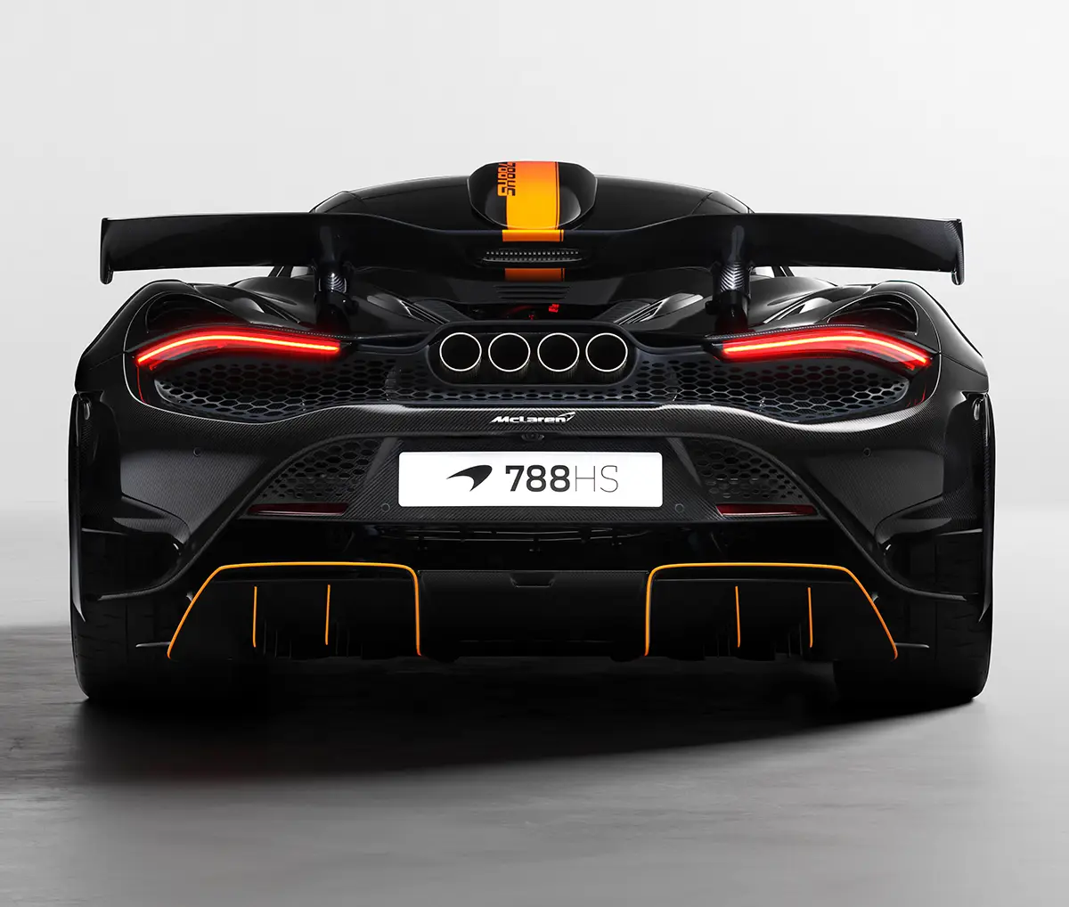 Heckansicht des schwarzen McLaren 788HS Coupés mit einem markanten, orangefarbenen Rennstreifen über das Dach und orange umrandeten F1-Diffusor-Finnen. Foto: McLaren