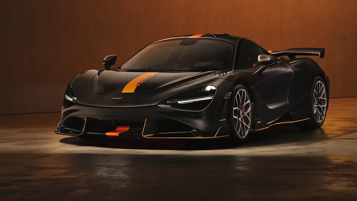 Dramatische Frontalansicht des neuen, dunkelgrauen McLaren 788HS Supersportwagens mit markanten orangefarbenen Akzentstreifen in einem stimmungsvoll dunkel und orange ausgeleuchteten Studio.