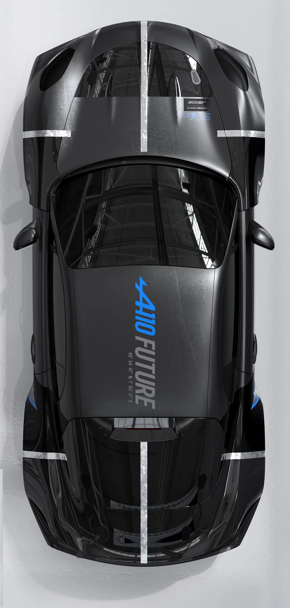 Minimalistische Draufsicht auf den Prototyp der Alpine A110 Future in dunklem Metallic-Grau mit einem blauen Schriftzug auf dem Dach und weissen Rennstreifen auf Front und Heck. Foto: Alpine