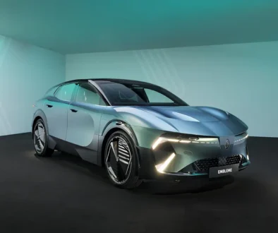 Schrägansicht von vorne auf das futuristische, silber-grün schimmernde Crossover-Konzeptfahrzeug Renault Emblème im Fotostudio.
