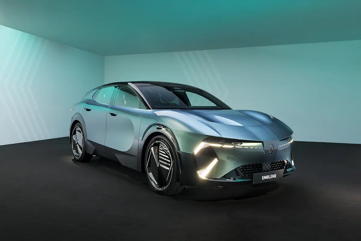Schrägansicht von vorne auf das futuristische, silber-grün schimmernde Crossover-Konzeptfahrzeug Renault Emblème im Fotostudio.