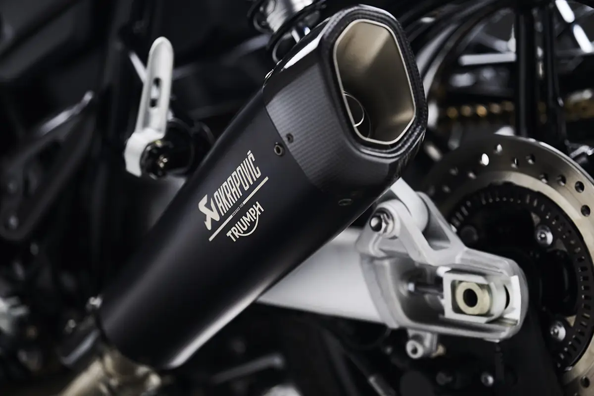 Nahaufnahme des schwarzen Akrapovič Titan-Endschalldämpfers mit eingraviertem Akrapovič- und Triumph-Logo an der Speed Twin 1200 TFC.
