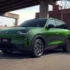 Ein moderner, giftgrüner Leapmotor B03X Elektro-Crossover steht im urbanen Raum auf einer Strasse unter einer Betonbrücke vor einem roten Backsteingebäude.