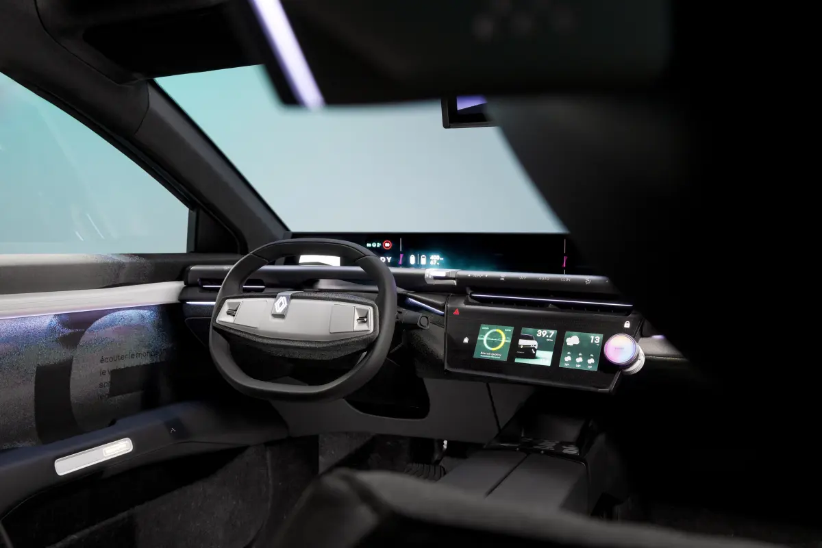 Blick in den futuristischen Innenraum des Renault Emblème mit hellem Cockpit, breitem Display-Band und eckigem Lenkrad.