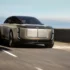 Frontansicht des futuristischen Bentley Elektro-SUV Konzeptwagens EXP 15 bei dynamischer Fahrt auf einer sonnigen Küstenstrasse.