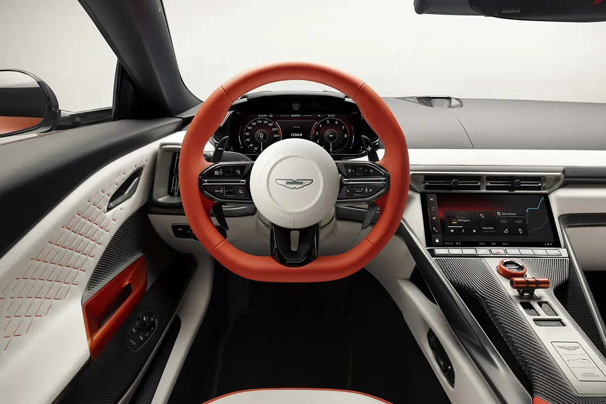 Blick in das Cockpit des Aston Martin Valen mit zweifarbigem weiss-rotem Leder-Sportlenkrad und digitalem Fahrerdisplay.