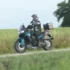 Fahrer auf der blauen CF Moto 800 MT-ES Reiseenduro mit Koffersystem beim Befahren eines Schotterwegs am Feldrain.