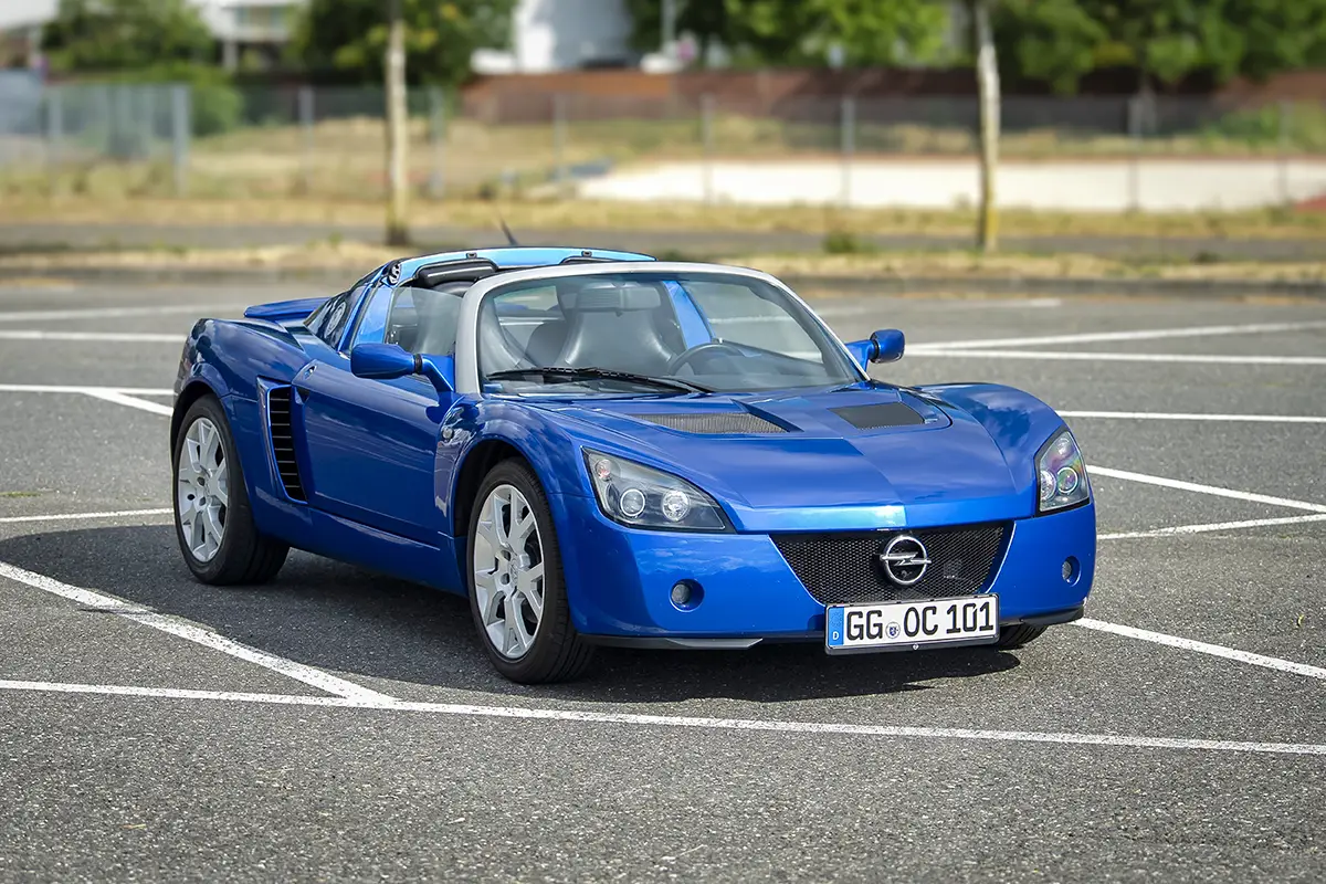 Front-Dreiviertelansicht des blauen Opel Speedster im Stand auf Asphalt.