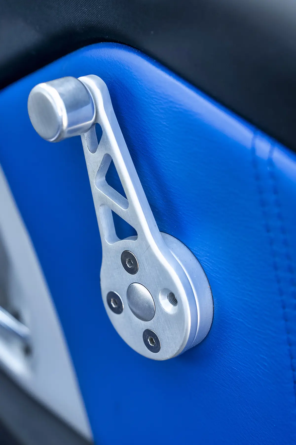 Ausgefräste Aluminium-Fensterkurbel zur Gewichtsreduktion an der blauen Türinnenverkleidung des Opel Speedster.