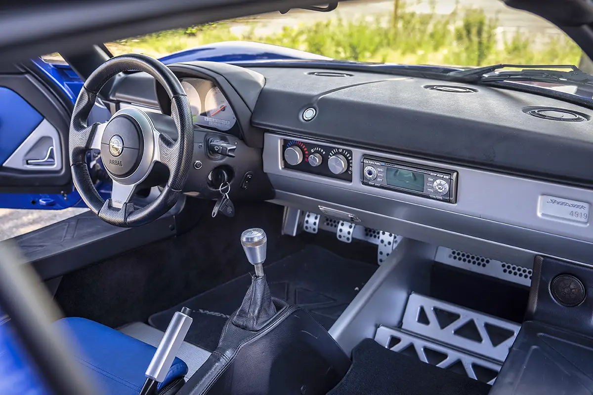 Puristischer Innenraum des Opel Speedster mit sichtbarem Aluminium, Sportsitzen, manuellem Schalthebel und Startknopf.