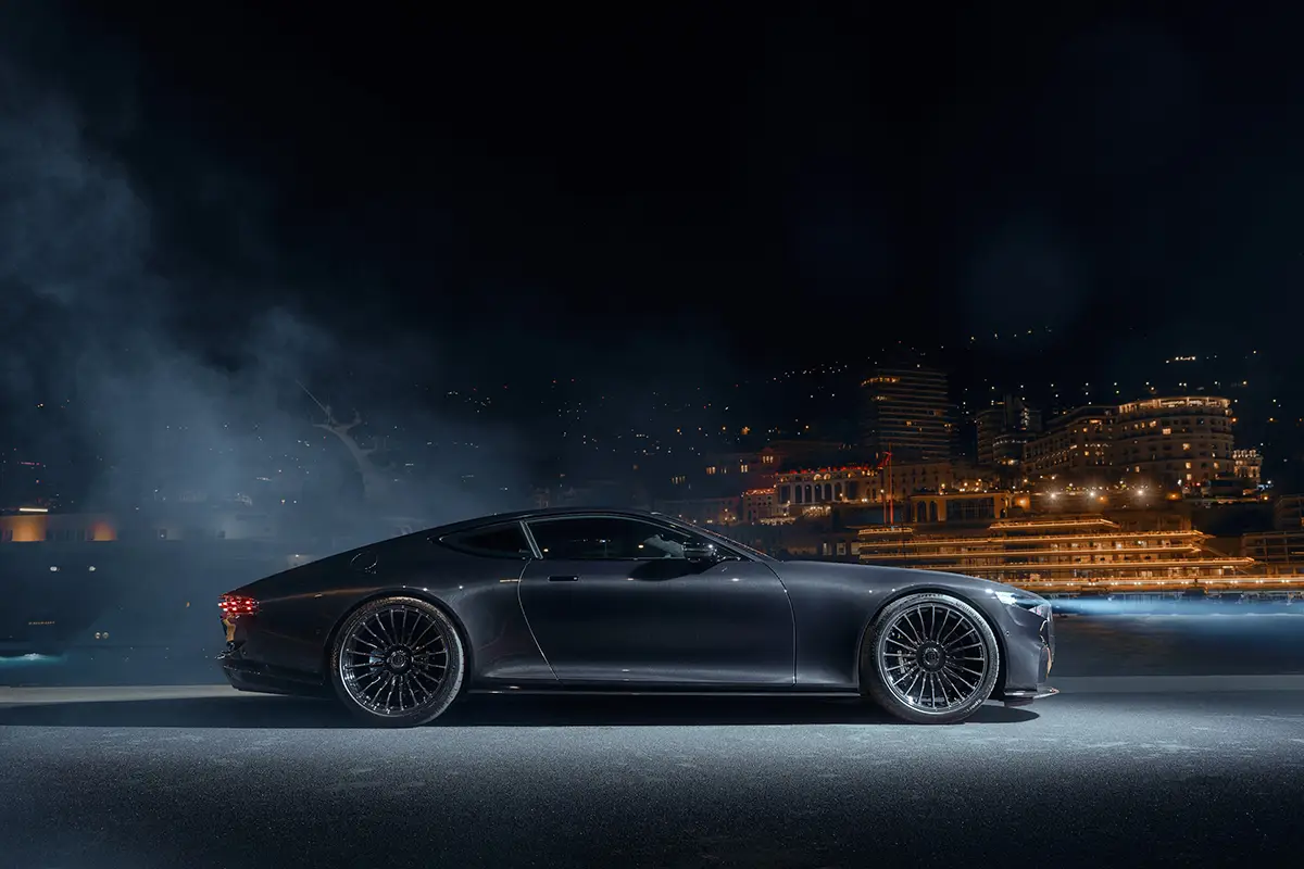 Seitenprofil des über fünf Meter langen Vollcarbon-Sportwagens Brabus Bodo in schneller Vorbeifahrt im warmen Abendlicht.