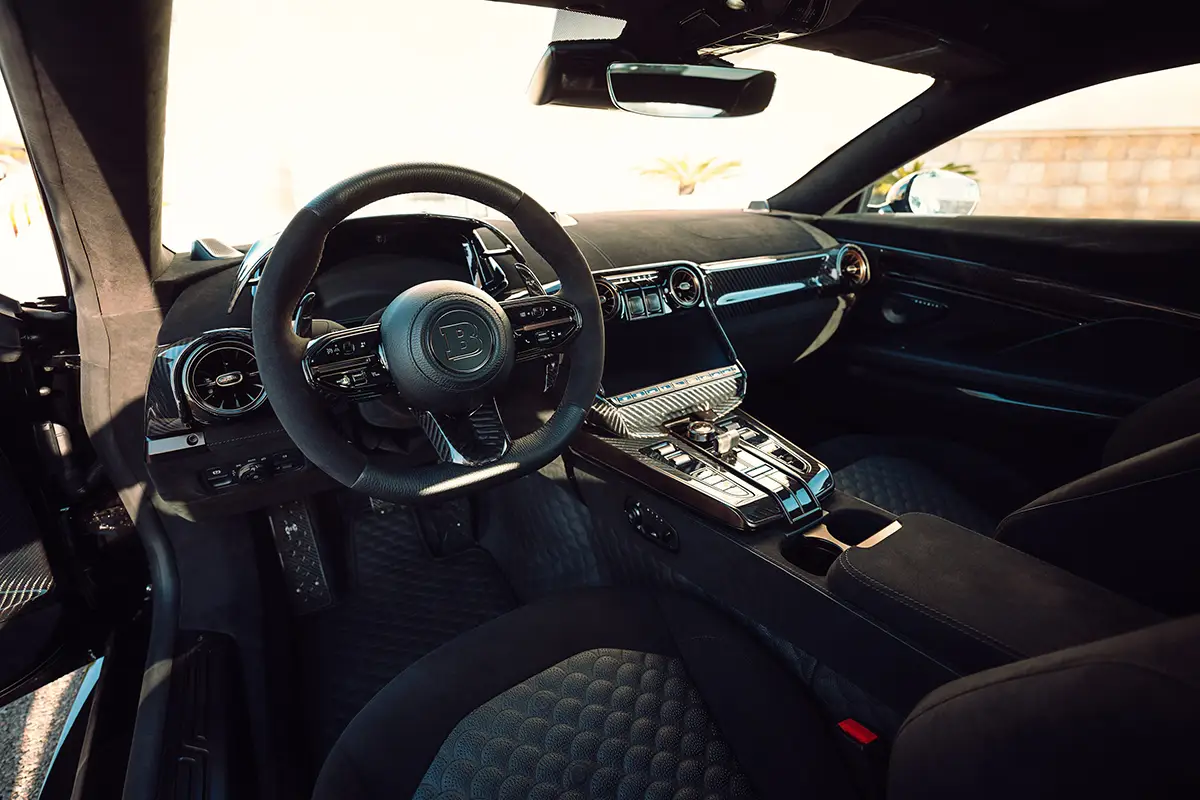 Dunkler Innenraum des Brabus Bodo mit feinstem Leder, Sportlenkrad und in Carbon eingewebten Goldpartikeln.