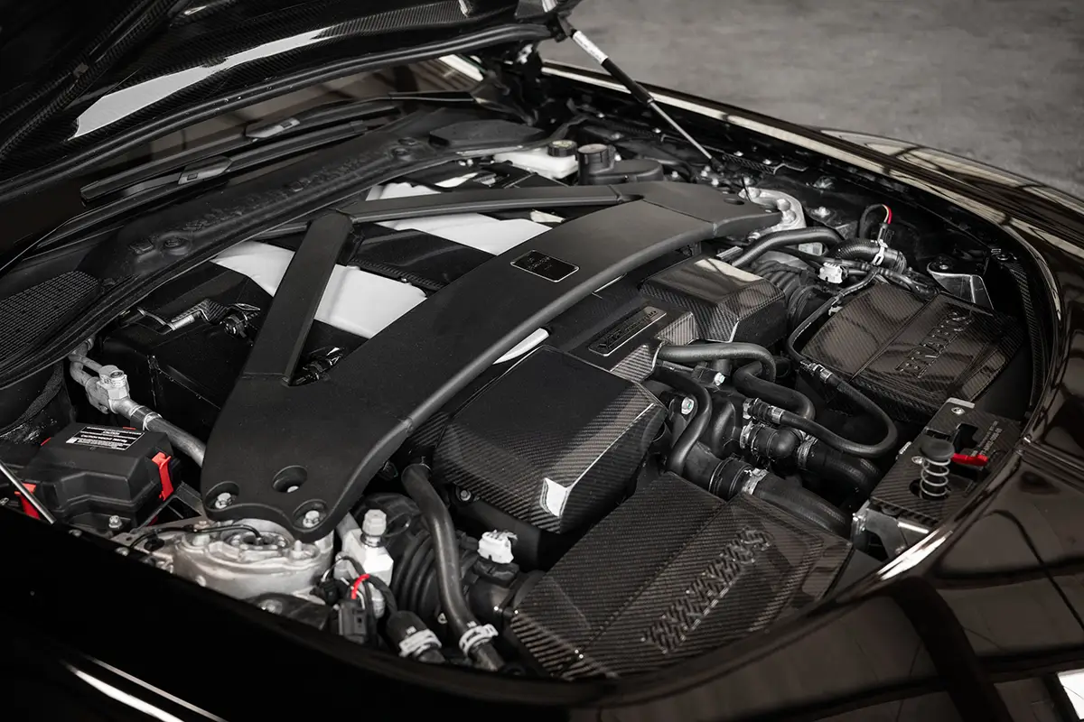 Detailansicht des 5,2-Liter-Biturbo-V12-Motors im Brabus Bodo mit massiver Carbon-Domstrebe und geschmiedeten Bauteilen.