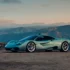 Seitenansicht des flachen Gordon Murray S1 Supersportwagens in Hellgrün vor einer Berglandschaft im Abendlicht.