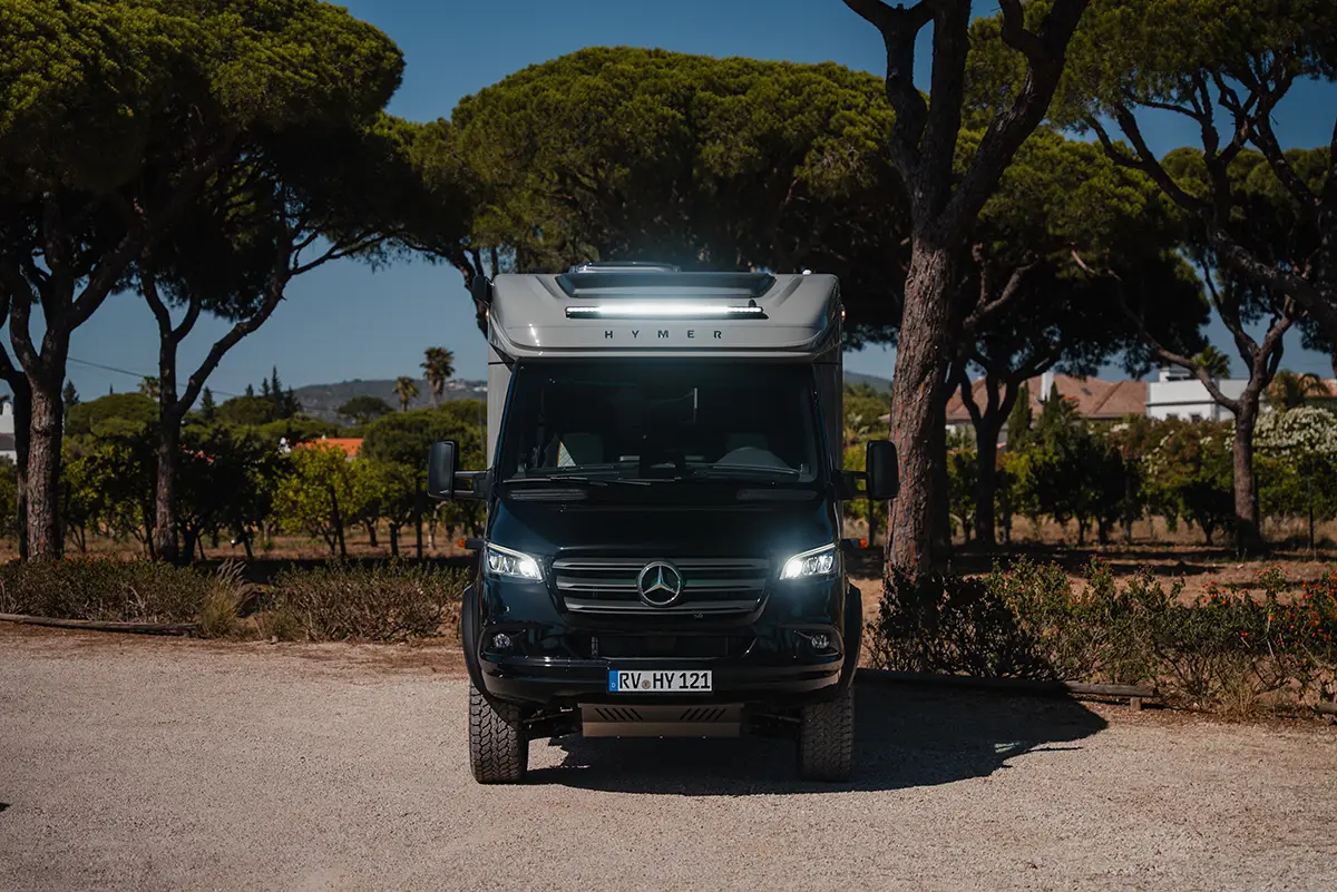 Frontalansicht des allradgetriebenen Hymer ML-T 570 CrossOver Offroad-Wohnmobils mit eingeschalteter LED-Lightbar über dem Fahrerhaus.