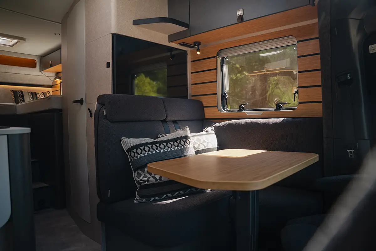 Blick in die Fahrerkabine des Hymer ML-T CrossOver mit umgedrehten Pilotensitzen und ausgeklapptem Tisch.