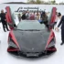 Frontalansicht des roten Lamborghini Revuelto SV mit geöffneten Scherentüren und Carbonhaube bei der Präsentation auf The Quail.