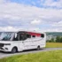 Kabe Imperial Ri830 Traq 4x4 vollintegriertes Allrad-Luxuswohnmobil auf Mercedes Sprinter auf einer Asphaltstrasse vor grüner Hügellandschaft.