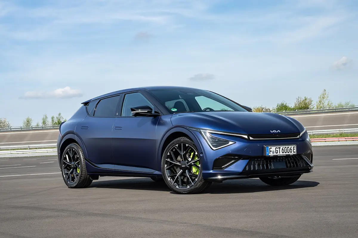 Dunkelblauer Kia EV6 Elektro-Crossover bei der Fahrt auf einer Teststrecke.