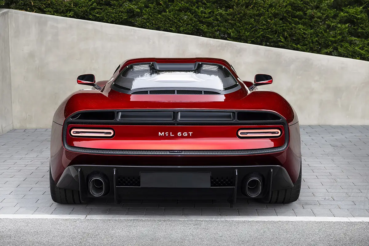 Direkte Heckansicht des McLaren McL 6GT mit schmalen LED-Rückleuchten, zwei Auspuffendrohren und markantem Kamm-Heck.