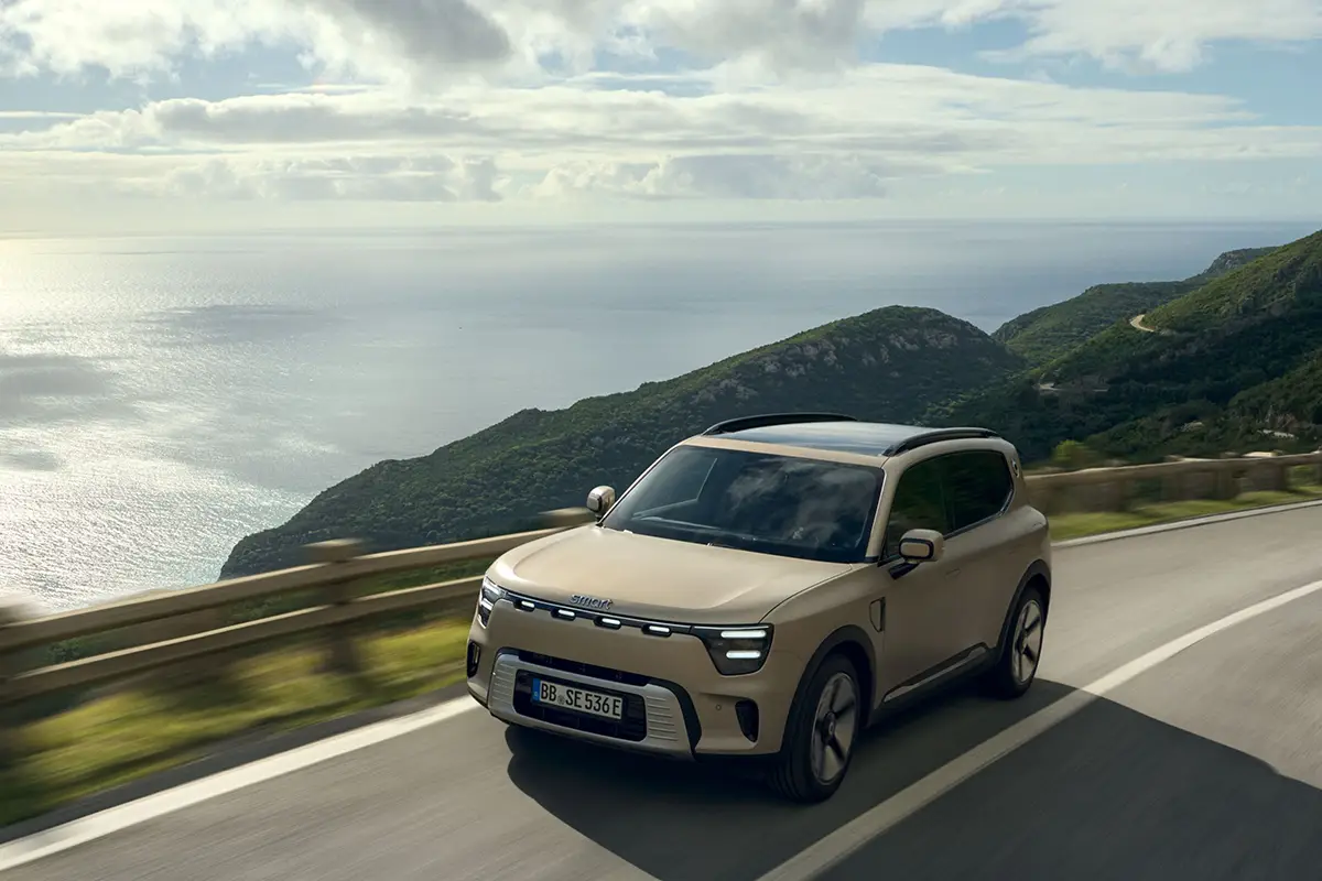 Beigefarbener Smart #5 SUV fährt auf einer gebirgigen Küstenstrasse.