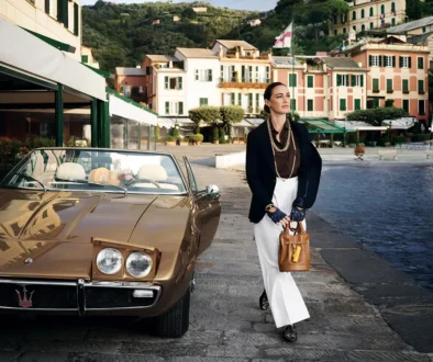 Klassischer Maserati Ghibli Spyder in Goldmetallic am Hafenbecken neben eleganter Dame