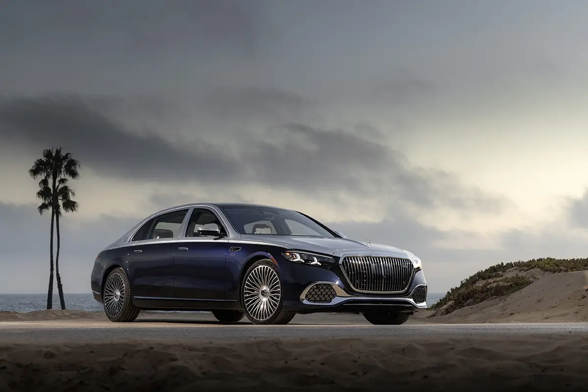 Zweifarbige Luxuslimousine Mercedes-Maybach S 680 mit V12-Biturbomotor an einer Küstenstraße neben einer Palme