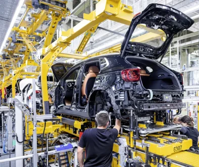 Automobilproduktion in der Fabrik mit Mitarbeiter am Montageband eines Elektro-Pkw zur wachsenden EU-Nachfrage
