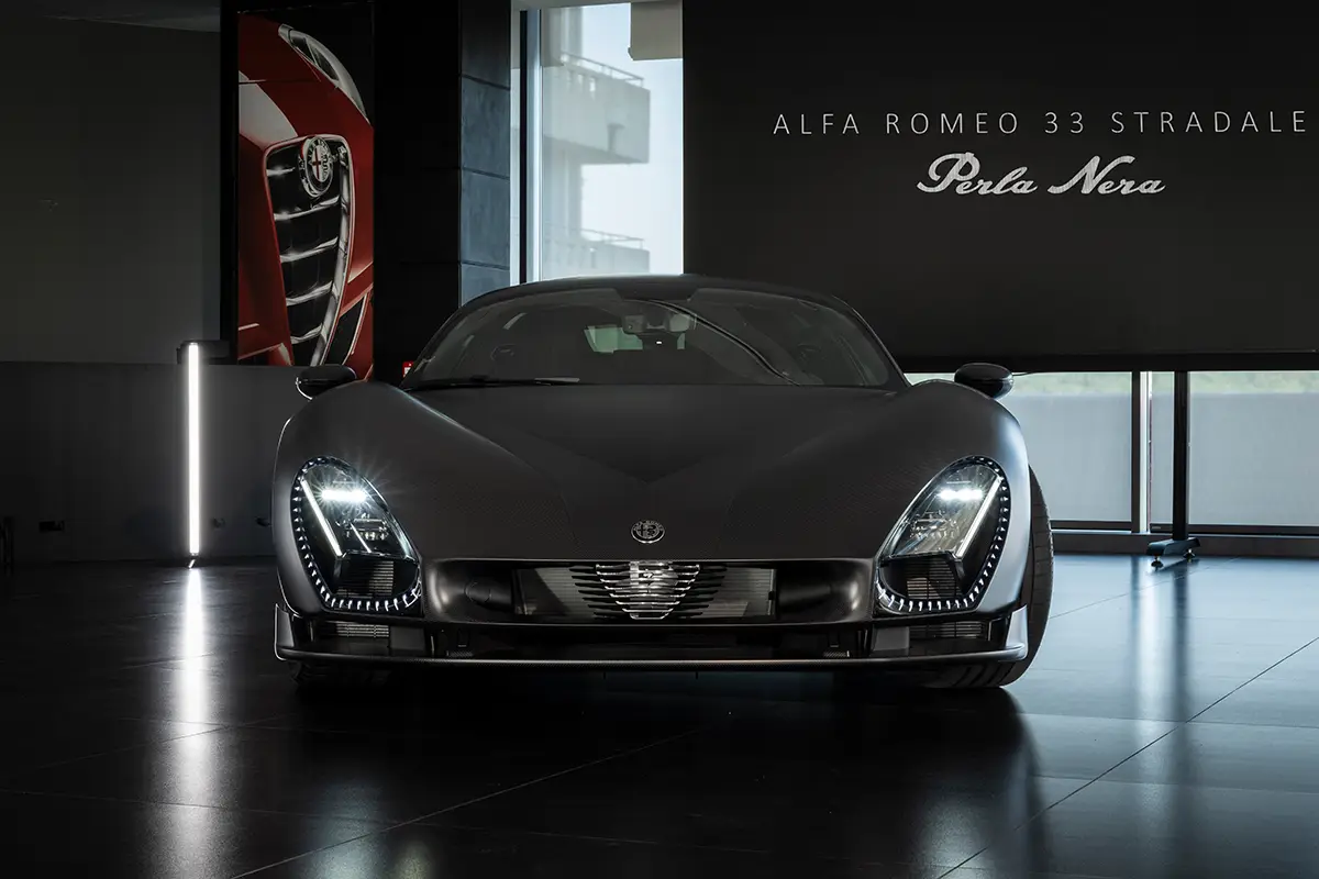 Frontansicht des 33 Stradale Perla Nera mit eingeschalteten LED-Scheinwerfern und sichtbarem Carbon-Gewebe