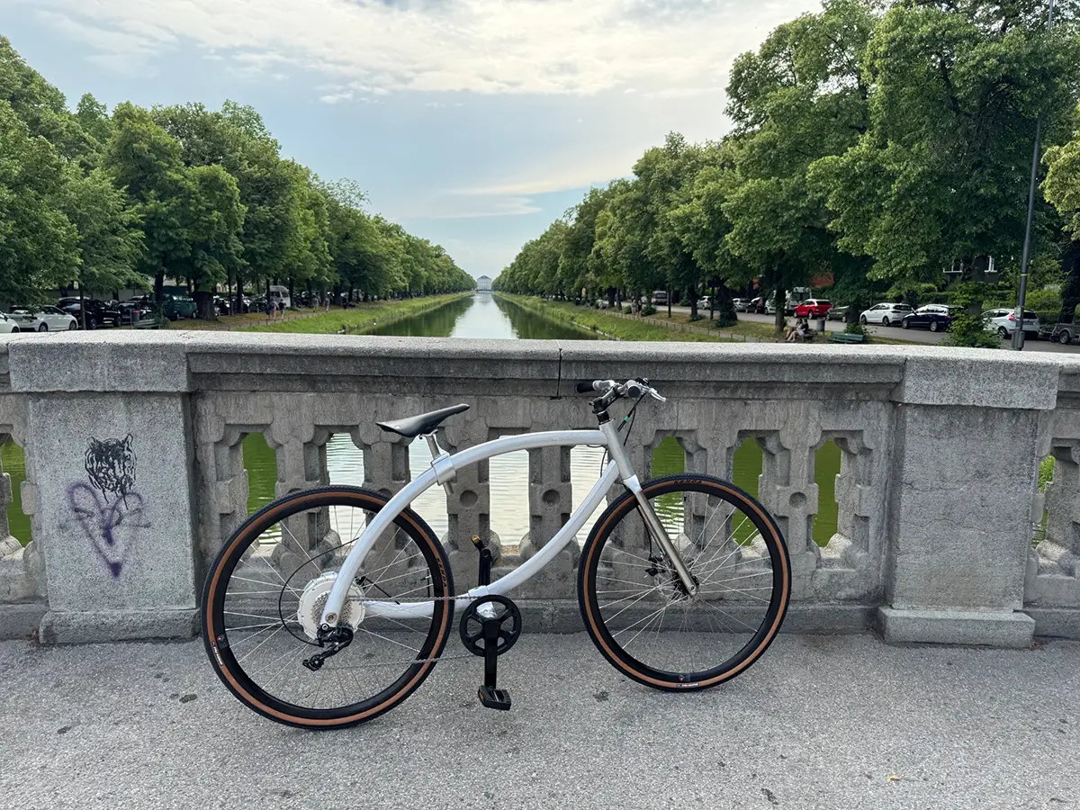 Schlankes NOVBYX E-Bike auf einer Brücke mit freiem Durchblick durch den minimalistischen Rahmen