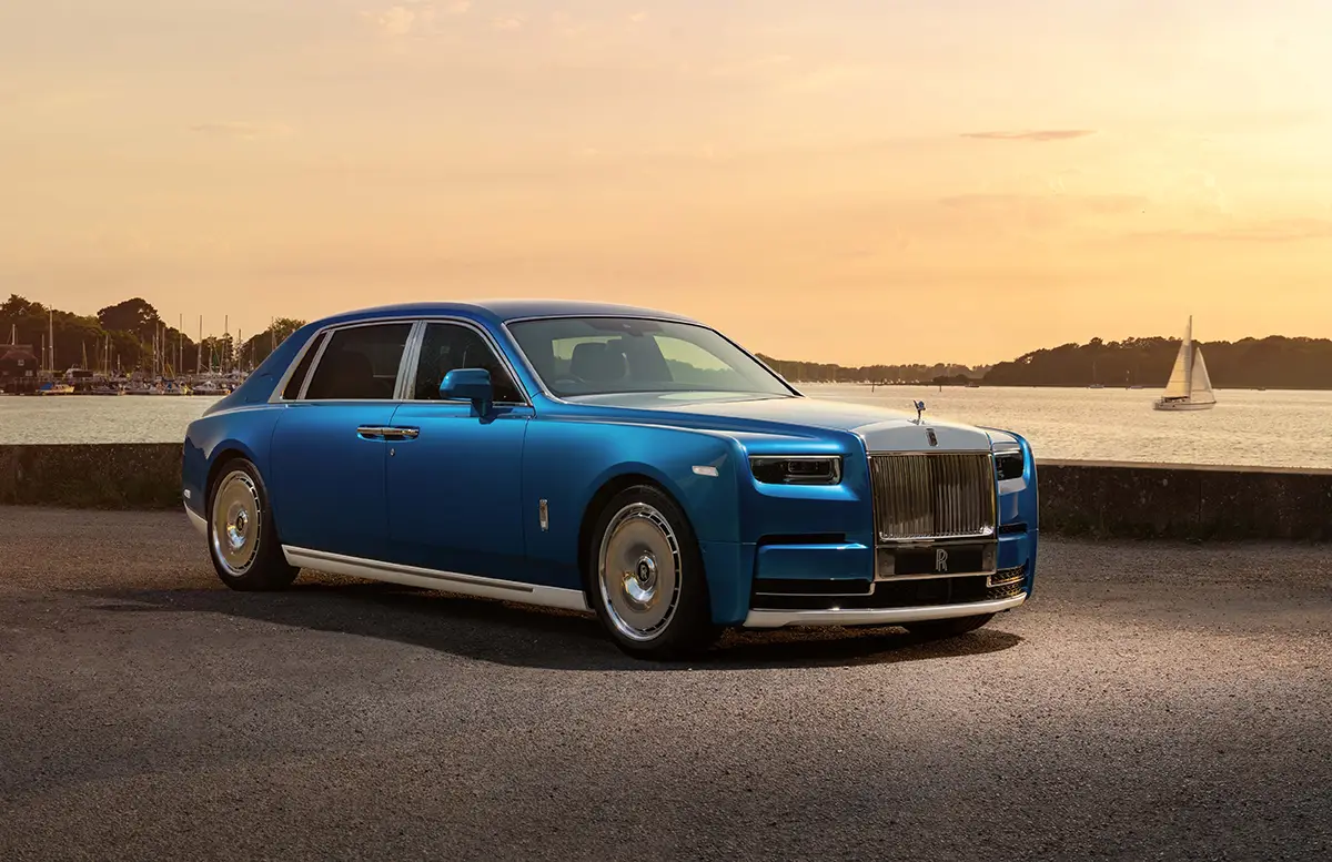 Blauer Rolls-Royce Phantom mit V12-Biturbomotor im Abendlicht an einer Uferpromenade