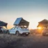 Drei Sportwagen mit aufgeschlagenen Dachzelten in freier Natur bei Sonnenuntergang als Beispiel für flexibles Micro-Camping.
