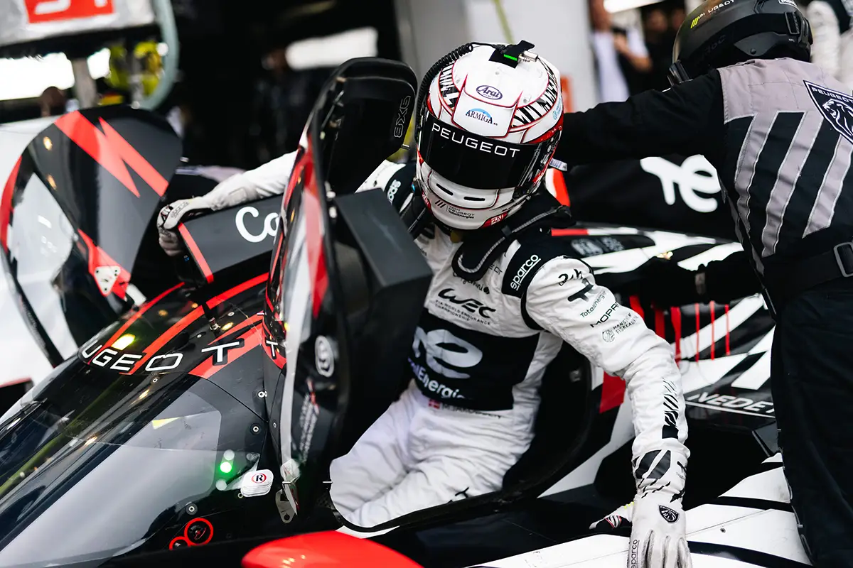 Loïc Duval öffnet die Cockpittür des PEUGEOT 9X8 bei einem Fahrerwechsel in der Box. Foto: Peugeot Sport
