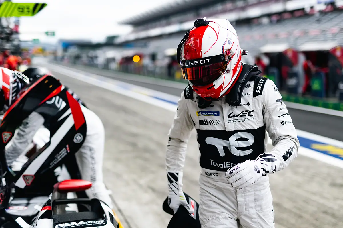 Rennfahrer Malthe Jakobsen von Team Peugeot TotalEnergies in voller Montur mit Helm im Fahrerlager von Fuji. Foto: Peugeot Sport