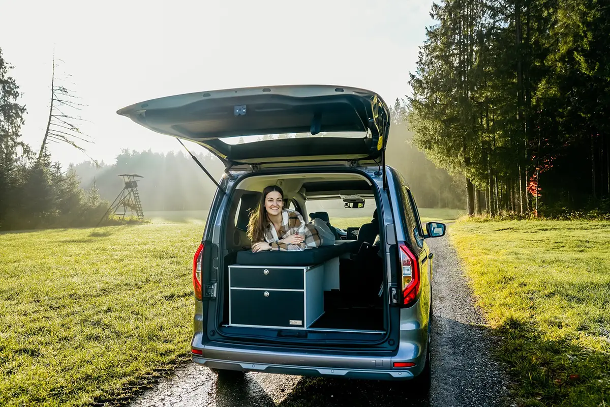 Blick in das offene Heck eines Nissan Townstar mit modularem Camping-Ausbausystem von Vanessa Mobilcamping.