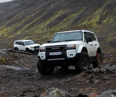 Weisser Toyota Land Cruiser mit 35-Zoll-Bereifung erklimmt eine felsige Geröllpiste im isländischen Hochland